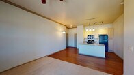 Located at 1187 Harness Rd in Monument, Colorado, this single-floor residence offers a well-designed, open-concept layout that seamlessly connects the living area to the kitchen. The living space features a combination of hardwood-style flooring and plush carpet, with crown molding accents and a ceiling fan providing both style and comfort. A sliding glass door leads to a private balcony, offering scenic views of the surrounding Colorado landscape, including mountain vistas on the horizon.

The kitchen is a functional highlight of the unit, showcasing light wood cabinetry, granite countertops, and a peninsula island with an integrated sink — ideal for meal prep and casual dining. Pendant lighting and track lighting illuminate the space, complementing the black appliance suite that includes a range, over-the-range microwave, and refrigerator.

The bedrooms are carpeted and generously sized, each equipped with a ceiling fan and ample natural light through windows with blinds. The bathroom features a full tub and shower combination with brushed nickel fixtures and tile flooring. Throughout the unit, neutral tones and consistent finishes create a clean, cohesive aesthetic well-suited to the Monument, CO setting.