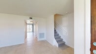 Located at 311 Gulfstream Rd in Dania Beach, Florida, this two-story, three-bedroom, three-bathroom home offers a thoughtfully distributed layout across two floors. The ground floor features a bright, open entryway with light-toned ceramic tile flooring that extends through the main living areas. A carpeted staircase leads to the upper level. The living room connects seamlessly to the dining area, which opens to the kitchen through a pass-through counter — ideal for entertaining. The kitchen is well-appointed with white cabinetry, granite countertops, a stone tile backsplash, stainless steel appliances including a range, dishwasher, and refrigerator, and ample overhead lighting. A patio provides outdoor access from the ground floor. Upstairs, the three bedrooms feature light hardwood-style flooring and generous natural light from large windows with outdoor views. The spacious primary bedroom includes direct access to a dedicated bathroom. Six closets throughout the home provide exceptional storage. The bathrooms are cleanly finished — one features a subway-tiled shower with sliding glass doors and marble-style tile flooring, while another includes a tub-shower combination. A dedicated laundry area and a balcony round out the upper level, completing this well-equipped South Florida home.