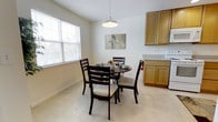 Located at 400 Haslet St in Dover, Delaware, this single-floor residence offers a clean, functional layout designed for comfortable everyday living. The kitchen and dining area form an open, cohesive space that serves as the heart of the home. Light-toned tile flooring runs throughout, contributing to a bright and airy atmosphere. The kitchen is outfitted with warm honey-toned wood cabinetry providing ample storage, white appliances, and light countertops that keep the space feeling fresh and practical. Adjacent to the kitchen, the dining area comfortably accommodates a round table with seating for four, centered beneath a modern pendant light fixture. A large window fitted with horizontal blinds allows generous natural light to fill the room, creating a welcoming environment throughout the day. The white walls and neutral color palette throughout the space lend a sense of openness and simplicity. The overall ambiance is clean and understated, with a layout that makes efficient use of space while maintaining a comfortable and livable feel. This residence at 400 Haslet St offers a straightforward, well-maintained environment in the heart of Dover, Delaware.