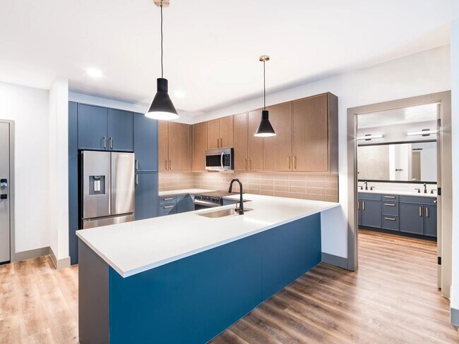 Una cocina moderna y minimalista con armarios de diseño llamativo, una amplia encimera e iluminación de diseño. - Modera Chandler