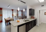 Located at 20941 San Simeon Way in Miami, FL, this well-appointed single-floor residence offers a thoughtfully designed open-concept layout that seamlessly connects the kitchen, dining, and living areas. The kitchen is a standout feature, boasting dark espresso cabinetry, granite countertops, a large peninsula with pendant lighting and an undermount double sink, and a full suite of stainless steel appliances including a refrigerator, range, microwave, and dishwasher. Tile flooring runs throughout the main living areas, while the open plan allows natural light to flow freely from multiple windows dressed with stylish accent curtains. The living room offers generous space with high ceilings, a ceiling fan, and track lighting. Two well-proportioned bedrooms feature plush carpeting, large windows, and ample natural light. Both bathrooms are finished with granite-topped dark vanities and tiled tub/shower combinations. A dedicated laundry area houses a full-size washer and dryer. The cohesive design palette of white walls, dark cabinetry, and warm accent tones creates a modern yet inviting atmosphere throughout this Miami residence.
