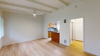 Located at 974 Haverford Ave in the desirable Pacific Palisades neighborhood of Los Angeles, this efficiently designed single-floor unit offers a thoughtful layout across its key living spaces. The living room serves as the heart of the home, showcasing striking exposed wood beam ceilings painted white, light hardwood-style flooring, and a ceiling fan that adds both function and charm. Natural light filters in through large windows, creating a bright and airy atmosphere throughout.

The kitchen is well-appointed with warm honey-toned cabinetry, dark granite countertops, a mosaic tile backsplash, and stainless steel appliances including a gas range and refrigerator. A pass-through opening connects the kitchen to the living area, enhancing the sense of openness. The hallway provides a smooth transition between the living and sleeping areas, with additional closet storage conveniently accessible along the way.

Storage is a standout feature of this unit, with four closets offering built-in shelving, hanging rods, and drawer units — providing generous organizational capacity. The bathroom is clean and modern, featuring a granite-topped vanity, subway-tiled shower/tub combination with glass sliding doors, and a window that brings in natural light. The cohesive use of hardwood flooring, neutral tones, and consistent finishes throughout gives the space a polished, unified feel.
