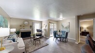 Located in Dallas, TX, this single-story 2-bedroom, 2-bathroom residence offers a thoughtfully designed layout that maximizes comfort and functionality. The open living and dining area serves as the heart of the home, featuring rich hardwood-style flooring, a brick fireplace, and a sliding glass door that invites natural light. The living room provides a warm, inviting atmosphere, while the adjacent dining area offers a dedicated space for meals and entertaining.

The kitchen is equipped with warm oak cabinetry, granite-style countertops, black appliances, and a double-basin sink. A breakfast bar with seating bridges the kitchen to the main living area, enhancing the open feel. Both bedrooms are carpeted and generously sized, with the primary bedroom offering a comfortable retreat complemented by natural light from a large window and ample closet space. Each bedroom is served by its own bathroom, with clean white tile tub-shower combinations.

Throughout the residence, neutral warm-beige tones on the walls provide a versatile backdrop, and the consistent flooring choices create a cohesive flow between spaces. Two dedicated closets add practical storage, completing this well-rounded and move-in-ready home.
