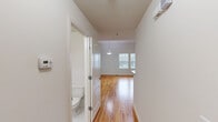 Located at 1 Rosewood Ave in Springfield, NJ, this two-story home offers 2 bedrooms and 3 bathrooms across two well-proportioned floors. Warm hardwood flooring flows consistently throughout both levels, creating a cohesive and inviting aesthetic.

The lower level houses the kitchen and living area, with the kitchen featuring rich cherry wood cabinetry, granite countertops, stainless steel appliances including a gas range, microwave, and refrigerator, and light tile flooring. A dedicated laundry room with a full-size washer and dryer adds everyday convenience. A hallway with a pendant light fixture leads to a bathroom on this floor.

The upper level is the larger of the two floors and hosts both bedrooms, including a spacious primary suite. The primary bedroom is particularly notable for its soaring vaulted ceiling with a skylight, triple windows that invite abundant natural light, and an en-suite bathroom with a glass-enclosed shower, tile flooring, and a vanity with granite countertops. The second bedroom is well-sized with a window overlooking the neighborhood. Two closets provide ample storage, including a walk-in with wire shelving. A warm wood-railed staircase connects the two floors, complementing the home's clean, neutral palette throughout.