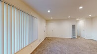 Located at 525 E Maude Ave in Sunnyvale, California, this single-floor unit offers a well-organized layout designed for comfortable everyday living. The galley-style kitchen is a standout feature, outfitted with rich warm-toned wood cabinetry, granite countertops, tile flooring, and white appliances including a gas range, microwave, and refrigerator — providing ample storage and workspace. Adjacent to the kitchen, the open living area is finished with neutral carpet and recessed lighting, creating a bright and welcoming atmosphere. Vertical blinds along the windows allow for natural light control throughout the main living space. A dedicated bedroom features carpeted flooring, a window with vertical blinds, and a ceiling light fixture, offering a quiet and functional retreat. A second carpeted room provides flexible space that can serve as an additional bedroom or den. The bathroom is well-appointed with tile flooring, a combination tub and shower enclosed by a sliding glass door, and chrome fixtures. Throughout the unit, clean white walls, consistent neutral finishes, and recessed lighting contribute to a cohesive, move-in-ready aesthetic suited for those seeking a practical home in the heart of Silicon Valley.