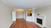 Located at 3301 Cotton Mill Dr in Raleigh, NC, this single-floor residence offers a well-designed layout that balances comfort and functionality. The main living area is bright and open, featuring warm hardwood-style flooring, neutral wall tones, and a classic fireplace with a white surround and marble-style hearth, serving as a natural focal point. Crown molding and clean white baseboards add architectural detail throughout the space.

The living area flows seamlessly into a dedicated dining space, illuminated by a pendant light fixture and defined by a tray ceiling. A pass-through window connects the dining area to the kitchen, enhancing the open feel. The kitchen is equipped with white shaker-style cabinetry, dark granite countertops, a gray subway tile backsplash, and stainless steel appliances, including a range, microwave, and dishwasher.

A separate room features large windows and a glass door opening to an outdoor balcony, allowing for generous natural light and outdoor views. The bathroom showcases a wide white vanity with ample counter space, a full-width mirror, and modern lighting. The floorplan, as visible in the dollhouse view, includes multiple rooms with a logical and efficient flow throughout the single-level layout.