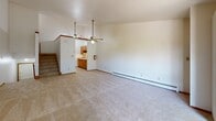 This two-story home in Greenfield, Wisconsin, offers a practical and functional layout spread across two floors. The main level serves as the heart of the home, featuring a generously sized combined living room and kitchen area. The living room is carpeted and includes dual ceiling fans and baseboard heating, creating a comfortable, well-ventilated space. The galley-style kitchen is efficiently arranged with warm oak cabinetry lining both sides, light-toned countertops, tile flooring, and includes a gas range and full-size refrigerator. A staircase connects the main level to the upper floor.

The upper level houses both bedrooms and two full bathrooms. The primary bedroom is a well-proportioned retreat featuring carpet flooring, a wall-mounted air conditioning unit, a large window that fills the room with natural light and outdoor views, and baseboard heating. The second bedroom offers sliding closet doors and plush carpet. A hallway connects the bedrooms and bathrooms, with built-in cabinetry providing additional storage. The bathrooms include a full tub-shower combination with a built-in shelf surround. Overall, the home provides a clean, straightforward layout suited for comfortable everyday living.