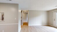 Located at 341 S Ellington Pkwy in Lewisburg, Tennessee, this single-floor, 2-bedroom, 3-bathroom home offers a well-organized layout designed for comfortable everyday living. Light-toned walls and consistent light hardwood flooring throughout the main areas create a clean, cohesive aesthetic. The living room is generously proportioned and features French doors that open to outdoor views of the surrounding greenery, filling the space with natural light. Adjacent to the living area, the galley-style kitchen is well-appointed with white shaker cabinetry, marble-look countertops, stainless steel appliances including a refrigerator, range, microwave, and dishwasher, complemented by a modern deep-basin sink. Both bedrooms are carpeted and offer a comfortable, quiet retreat; the primary bedroom is notably spacious with room for a full furniture arrangement, while the secondary bedroom includes a window with outdoor views. The three bathrooms include a tub-shower combination unit with clean white fixtures. A dedicated laundry area with washer and dryer hookups adds practical convenience. A hallway with hardwood flooring connects the rooms efficiently, and a closet provides additional storage. Textured ceilings are present throughout, and the exterior features a covered entryway with a decorative pergola.