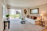 Located at 5600 Orangethorpe Ave in La Palma, California, this single-story residence offers a well-organized and comfortable layout with a warm, inviting ambiance throughout. The living room serves as the centerpiece of the home, featuring plush carpeting, crown molding, and a textured ceiling. Large sliding glass doors flood the space with natural light and open to a view of lush greenery, creating a seamless indoor-outdoor connection. A framed wall mirror and decorative accents add character to the room.

The galley-style kitchen is efficiently designed with white cabinetry, white appliances including a range and refrigerator, a dishwasher, and light hardwood flooring, offering a clean and functional workspace.

The bedroom is a tranquil retreat, carpeted for comfort and brightened by a sizable window with vertical blinds. The room provides ample space for a full dresser and bedside tables, complemented by subtle wall décor that contributes to its calm atmosphere.

The bathroom features hardwood-style flooring, a shower-tub combination, and a white vanity with generous counter space, maintaining the clean and neutral aesthetic found throughout the home. Overall, the residence presents a cohesive, comfortable living environment in the heart of La Palma.