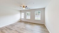 Located at 1375 Companion Ct in Sumter, South Carolina, this single-story, 2-bedroom, 2-bathroom home offers a well-designed layout with a clean, modern aesthetic throughout. The open-concept living area features light-toned luxury vinyl plank flooring, neutral white walls, and a ceiling fan, with multiple windows fitted with blinds that allow ample natural light to fill the space. A glass-paneled door provides direct outdoor access from the living room.

The kitchen is a standout feature, equipped with gray shaker-style cabinetry, white countertops, and a full suite of stainless steel appliances including a range, microwave, and refrigerator. A center island with a built-in sink and pendant lighting above adds both function and style, while the LVP flooring continues seamlessly from the living area.

Both bedrooms are carpeted and offer a calm, neutral environment. The spacious primary bedroom includes a ceiling fan and a window with outdoor views. Both bathrooms are finished consistently with gray vanity cabinetry, white countertops, large mirrors, and warm vanity lighting, with LVP flooring tying into the home's cohesive design. A dedicated closet and hallway complete the thoughtfully organized floor plan.