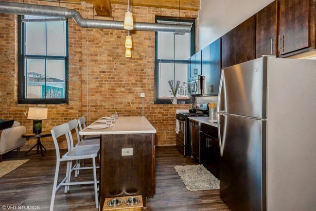 Cocina con barra de desayuno - Carriage House Lofts