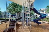The Ranch Playground is a thoughtfully designed outdoor recreational area, spanning a modest 60 square feet. This single-level space is dedicated to providing a safe and engaging environment for children to play and explore. The playground is equipped with a variety of age-appropriate structures, carefully selected to promote physical activity and imaginative play.

The layout maximizes the available space, incorporating multiple play elements within its compact footprint. Visitors can expect to find classic playground features such as swings, slides, and climbing structures, all scaled to fit the area efficiently. The ground is likely covered with safety-conscious materials like rubber mulch or soft synthetic turf to cushion falls and ensure a clean play surface.

Despite its small size, The Ranch Playground likely offers zones for different types of play, possibly including a sandbox for tactile exploration, a small open area for group games, and strategically placed seating for adult supervision. The design may draw inspiration from its "Ranch" theme, potentially incorporating rustic or western-style elements in the structure's aesthetics or play features.

Natural elements such as trees or shrubs might border the playground, providing shade and a pleasant backdrop. Adequate lighting may be installed to extend usability into the early evening hours, as hinted by the dim illumination visible in one of the provided images.

Overall, The Ranch Playground represents a well-thought-out use of limited space, creating a fun and functional outdoor area for community children to enjoy.