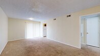 Located at 4110 Arthur Ln in Beaumont, TX, this single-story, one-bedroom, one-bathroom unit offers a functional and efficient layout. The combined living and dining area is a welcoming open space featuring a mix of wood-look hard flooring and plush carpet, neutral white walls, a textured ceiling, and a sliding glass door dressed with vertical blinds that allows natural light to fill the room. A hallway connects the living area to the private quarters of the home. The generously sized bedroom features wall-to-wall carpet, a ceiling fan with light fixture, a window with blinds for natural light, and notably, dual closets providing ample storage. The full bathroom includes a tub and shower combination with clean white surrounds, alongside standard fixtures. The galley-style kitchen is equipped with wood-toned cabinetry, a white refrigerator, electric range, dishwasher, and hard flooring, making efficient use of the available space. Four closets throughout the unit offer substantial storage options. The neutral color palette and straightforward layout throughout create a clean, move-in ready environment suitable for comfortable single-occupant or couple living.