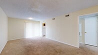 Located at 4110 Arthur Ln in Beaumont, TX, this single-story, one-bedroom, one-bathroom unit offers a functional and efficient layout. The combined living and dining area is a welcoming open space featuring a mix of wood-look hard flooring and plush carpet, neutral white walls, a textured ceiling, and a sliding glass door dressed with vertical blinds that allows natural light to fill the room. A hallway connects the living area to the private quarters of the home. The generously sized bedroom features wall-to-wall carpet, a ceiling fan with light fixture, a window with blinds for natural light, and notably, dual closets providing ample storage. The full bathroom includes a tub and shower combination with clean white surrounds, alongside standard fixtures. The galley-style kitchen is equipped with wood-toned cabinetry, a white refrigerator, electric range, dishwasher, and hard flooring, making efficient use of the available space. Four closets throughout the unit offer substantial storage options. The neutral color palette and straightforward layout throughout create a clean, move-in ready environment suitable for comfortable single-occupant or couple living.