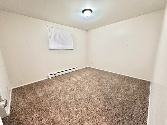Dormitorio amplio y luminoso con alfombras de felpa y una lámpara moderna, que ofrece un ambiente acogedor y atractivo. - 7250-7290 Newton Street
