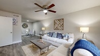 Located at 1550 Blalock Rd in Houston, TX, this two-story home offers 2 bedrooms and 3 bathrooms thoughtfully distributed across two floors. The main level features an open-concept living and dining area with warm hardwood-style flooring, neutral gray walls, and ceiling fans throughout. The living room is bright and welcoming, highlighted by natural light from large windows, and flows seamlessly into the dining area. The kitchen is well-appointed with white shaker-style cabinetry, light countertops, a gray subway tile backsplash, and black appliances, including a refrigerator and dishwasher. The bathrooms feature white vanities with under-cabinet storage, mirrored medicine cabinets, and clean, modern finishes. One bathroom includes a soaking tub with white tiled surround. The primary bedroom, located on the upper floor, is a comfortable retreat with a ceiling fan, natural light from a window, and access to a closet. The second bedroom also features a ceiling fan, window, and its own closet for ample storage. Hardwood-style flooring runs consistently throughout both levels, tying the home together with a cohesive, contemporary aesthetic. Two staircases connect the floors, and a hallway provides convenient circulation between rooms.