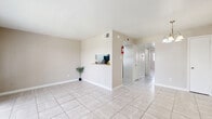 Located at 6833 Beechnut St in Houston, TX, this single-floor, 2-bedroom, 2-bathroom home offers a practical and well-organized layout with tile flooring throughout. The bright living room features light-toned large-format tiles, neutral walls, and a pass-through view into the kitchen, creating an open, connected feel. Adjacent to the living area, the dining room is accented by a pendant chandelier and ample space for a four-seat table. The galley-style kitchen is efficiently designed with gray cabinetry, granite-style countertops, black appliances including a range and refrigerator, and a double sink — maximizing functionality within a compact footprint. The spacious primary bedroom includes a ceiling fan and access to closet space, while the second bedroom mirrors similar proportions and comfort. Both bathrooms are finished with large-format gray wall tiles surrounding full tub-and-shower combinations, tile flooring, and gray vanities with granite-style countertops. Five closets distributed throughout the home offer exceptional storage. The layout flows smoothly from common areas to private spaces via a central hallway, making efficient use of every square foot in this well-appointed Houston residence.