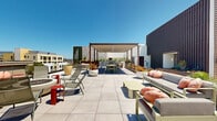 Located at 1430 Lincoln Blvd in Santa Monica, California, this rooftop amenity level offers a thoughtfully designed outdoor living experience with multiple distinct zones. The expansive deck is finished with large-format porcelain pavers throughout, lending a clean, contemporary aesthetic to the entire space.

A generously sized open-air lounge area is anchored by a round fire pit and surrounded by comfortable outdoor seating, providing panoramic views of the Santa Monica and greater Los Angeles skyline under open skies. A separate, more intimate seating vignette features modern outdoor sofas and low tables framed by Corten steel planter beds filled with colorful, drought-tolerant landscaping.

An outdoor kitchen and dining area sits beneath a sleek shade pergola, equipped with a professional-grade grill and ample counter space, making it well-suited for entertaining. Adjacent raised planters feature a curated mix of succulents and ornamental grasses that add natural texture and color throughout.

Large sliding glass doors connect the rooftop directly to an interior lounge room furnished with contemporary seating, offering a seamless indoor-outdoor flow. An elevator provides convenient access to the level. The combination of abundant natural light, open sightlines, verdant landscaping, and refined architectural detailing makes this rooftop a standout communal amenity in the heart of Santa Monica.