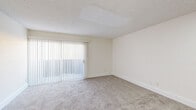 Located in Glendale, Arizona, this two-story, 1-bedroom, 1-bathroom home offers a well-organized layout spread across two floors. The main level features a galley-style kitchen finished with crisp white cabinetry, light wood-look flooring, a gas range, stainless steel refrigerator, and a window that brings in natural light. Adjacent to the kitchen, the living room is generously proportioned with plush carpeting, a textured ceiling, and a large sliding glass door with vertical blinds that fills the space with abundant natural light. A staircase with a clean white railing connects the two floors, adding a sense of verticality to the home. Upstairs, the primary bedroom is a comfortable retreat featuring soft carpeting, neutral walls, a window with exterior views, and a nearby closet. The full bathroom is finished with light wood-look flooring, a white vanity with a single sink, a mirror, and a clean, simple design. Throughout the home, a consistent neutral color palette of whites and warm beiges creates a bright, cohesive atmosphere. The thoughtful two-floor design efficiently maximizes the available living space, making this Glendale home both functional and inviting.