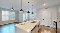 Located at 9292 Grand Cordera Pkwy in Colorado Springs, CO, this well-designed one-bedroom, one-bathroom residence offers a thoughtfully organized single-floor layout. The open-concept living and kitchen area serves as the heart of the home, where warm wood-look flooring, neutral walls, and abundant natural light from multiple windows create a bright, welcoming atmosphere. A ceiling fan adds comfort to the living room, which also features a private entrance door.

The kitchen is a standout, centered around a large island with a white quartz countertop, an undermount sink, and a pull-down faucet. Three stylish black pendant lights hang above the island, while the cooking area showcases gray cabinetry with black hardware, a herringbone tile backsplash, and stainless steel appliances including a refrigerator, range, and dishwasher. A hallway connects the main living areas to the private spaces.

The bedroom is carpeted, ceiling fan-equipped, and includes a generously sized walk-in closet with multi-tiered shelving and built-in organizers. The bathroom features a soaking tub and shower combo with large-format marble-look tile surround, lending a clean, spa-like aesthetic to the space.