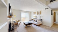 This well-appointed 2-bedroom, 3-bathroom residence in Lakewood, Colorado offers a thoughtfully designed single-floor layout that maximizes every square foot. The living room serves as the heart of the home, featuring plush carpeting, a textured ceiling, and a sliding glass door that opens to a private balcony, flooding the space with natural light and providing outdoor access. The galley-style kitchen is efficiently organized with warm oak cabinetry, granite-look countertops, hardwood-style flooring, and a full suite of black stainless appliances including a range, microwave, refrigerator, and dishwasher. The primary bedroom offers a comfortable retreat with carpeted floors, a window with natural light, and a walk-through closet corridor lined with sliding wood-panel doors leading to an en-suite bathroom. The en-suite features oak vanity cabinetry and hardwood-style flooring. A second bedroom with a large sliding closet doubles as a flexible office space, also carpeted and naturally lit. Three bathrooms provide ample convenience for residents and guests alike. Throughout the home, warm wood-toned accents, neutral walls, and consistent flooring choices create a cohesive and inviting ambiance.