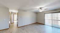 Located at 1600 E Windmill Way in Republic, Missouri, this single-floor unit offers a practical and comfortable layout designed for everyday living. The open-concept living and kitchen area serves as the heart of the space, where light vinyl plank flooring extends throughout, lending a clean, cohesive aesthetic. A ceiling fan overhead provides both airflow and ambient lighting, while neutral-toned walls create a bright, welcoming atmosphere.

The kitchen is efficiently designed with warm honey-toned cabinetry offering generous storage, a peninsula with a built-in sink that doubles as a breakfast bar, and stainless steel appliances including a range, microwave, and dishwasher. A black refrigerator anchors the appliance suite. Adjacent to the kitchen, the living area flows naturally toward a sliding glass door that invites natural light.

The bedrooms feature plush carpet flooring and include well-organized closets with wire shelving systems. One bedroom benefits from a window with an outdoor view. A dedicated laundry closet houses a full-sized washer and dryer, adding notable convenience. The bathroom includes a full tub-shower combination with chrome fixtures. Warm wood-toned door trim and baseboards throughout provide a consistent, finished look across all rooms.