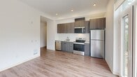 Located at 629 Woodland Square Loop SE in Lacey, WA, this one-bedroom, one-bathroom unit offers a thoughtfully designed layout with modern finishes throughout. Wood-look plank flooring flows consistently across all areas, lending a clean, cohesive aesthetic to the space.

The kitchen is a standout feature, equipped with stainless steel appliances including a refrigerator, electric range, microwave, and dishwasher. Dark wood-toned cabinetry is complemented by a classic white subway tile backsplash, creating a contemporary contrast. Recessed lighting illuminates the space, and a glass door opens directly to a private patio, allowing natural light to fill the area.

The bedroom is generously proportioned, featuring large windows that invite abundant natural light and offer views of the surrounding greenery. Vaulted ceiling lines add a sense of openness, and the room is served by convenient hallway access.

The bathroom is clean and well-appointed, featuring a full tub and shower combination, a dark-cabinetry vanity with a white countertop sink, wood-look flooring, and matte black hardware accents. Two hallways connect the rooms efficiently, contributing to a practical and functional floor plan. The overall ambiance is bright, modern, and move-in ready.