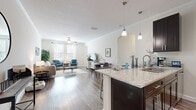Located at 14746 Westbrook Cir in Bradenton, Florida, this single-story residence offers a well-designed open-concept floor plan that seamlessly connects the kitchen, dining, and living areas. The kitchen serves as a central hub of the space, featuring dark espresso cabinetry, light granite countertops, stainless steel appliances, and a large island with pendant lighting overhead. Track lighting and crown molding add refined detail throughout. Hardwood-style flooring extends across the main living areas, complementing the neutral, light-toned walls and creating a cohesive, contemporary aesthetic.

The living room is bright and welcoming, with multiple windows allowing generous natural light and a ceiling fan providing comfort year-round. An elegant arched passageway connects the living area to additional rooms, lending architectural character to the layout. The bedrooms feature plush carpeting and ample natural light, providing a comfortable retreat.

The bathroom mirrors the kitchen's design language, with matching dark cabinetry, granite countertops, and a large vanity mirror. A dedicated laundry area houses a full-size Samsung washer and dryer with overhead shelving for added storage. Overall, the space delivers a modern, functional, and cohesive living environment.