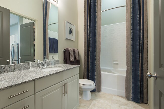 Baños con encimeras de granito y bañeras profundas. - 2700 Charlotte Ave Apartments
