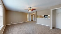Located at 190 Gateway Dr in Biloxi, Mississippi, this one-bedroom, one-bathroom residence offers a well-organized, single-floor layout designed for comfortable everyday living. The open-concept living and kitchen area serves as the heart of the home, where soft, neutral-toned walls and plush wall-to-wall carpeting create a warm and inviting atmosphere. A ceiling fan with a light fixture anchors the living space, enhancing airflow and comfort. The kitchen is thoughtfully laid out in a galley-style configuration, featuring white cabinetry with wood-tone accents, light stone countertops, a double sink, and black appliances including a refrigerator, range, microwave, and dishwasher. Wood-look flooring runs through the kitchen, adding a clean contrast to the carpeted living areas. The spacious bedroom benefits from natural light through large windows fitted with blinds, a ceiling fan, and a generous closet with built-in shelving. The bathroom is finished with a single-sink vanity, wood-accented cabinetry, a large mirror, and wood-look flooring. A dedicated laundry room with washer and dryer hookups adds everyday convenience. Three closets throughout the unit provide ample storage for all needs.