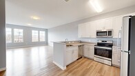 Located at 33 Old Tavern Rd in Orange, Connecticut, this single-floor residence offers a well-designed layout with three bedrooms and two full bathrooms. The interior features a clean, contemporary aesthetic with light hardwood-style flooring and soft gray walls carried consistently throughout the home.

The open-concept kitchen serves as the heart of the space, equipped with crisp white shaker cabinetry, stainless steel appliances including a range, microwave, dishwasher, and refrigerator, and a peninsula with a built-in sink that seamlessly connects to the living area. The living room benefits from natural light through a set of windows, creating an airy, welcoming atmosphere.

The spacious primary bedroom features multiple large windows with outdoor views, flooding the room with natural light. The additional bedrooms are well-proportioned, each equipped with wall-mounted mini-split HVAC units and windows that bring in natural light.

Both bathrooms are finished in a consistent modern style, featuring gray vanities with white countertops, large mirrors, and tile flooring. One bathroom includes a glass-enclosed walk-in shower, while the second offers a shower-tub combination with sliding glass doors.

A connecting hallway ties the layout together efficiently, making this a functional and stylish single-level home.