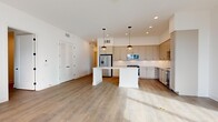 Located at 468 Quay Commons in the heart of Sarasota, FL, this thoughtfully designed 3-bedroom, 3-bathroom residence offers a clean, contemporary aesthetic across a well-appointed single-floor layout. Light wood flooring flows throughout, tying together a cohesive and modern interior palette of soft whites and warm neutrals.

The open-concept kitchen serves as a central hub, featuring shaker-style cabinetry in a muted greige tone, stainless steel appliances including a french-door refrigerator, stove, microwave, and wine cooler, all complemented by white quartz countertops and a herringbone tile backsplash. A central island with pendant lighting adds both functionality and visual interest, while recessed lighting illuminates the space.

Each of the three bedrooms offers a bright, clean environment with light-filled interiors. The primary bedroom includes access to a private balcony through floor-to-ceiling sliding glass doors, offering views of the Sarasota skyline. A dedicated hallway leads to the spacious primary bathroom, which boasts a large-format tile floor, an extended dual vanity, and a walk-in glass-enclosed shower. The additional bathrooms echo the same refined finishes with tile flooring and modern fixtures. Two closets and two hallways provide practical storage and easy circulation throughout the residence.