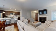 Located at 233 Lake Ave in the heart of Saratoga Springs, NY, this well-appointed single-floor residence offers 2 bedrooms, 3 bathrooms, a dedicated office, and a thoughtfully designed open-concept layout. Rich hardwood flooring flows throughout the main living areas, anchoring the bright and welcoming atmosphere from the moment you enter. The spacious living room is a standout, featuring a granite-surround fireplace, large windows that invite abundant natural light, and seamless access to the dining area—ideal for both relaxed living and entertaining. The kitchen is outfitted with dark espresso cabinetry, quartz countertops, a marble-style backsplash, and a full suite of stainless steel appliances, including a dishwasher, range, microwave, and refrigerator. A breakfast bar provides casual seating alongside the open dining space, which is brightened by multiple windows. The primary bedroom offers comfortable proportions with plush carpeting and closet access. A dedicated office with built-in shelving provides a functional workspace with natural light. Three full bathrooms include a glass-enclosed walk-in shower. A private in-unit laundry room with full-size washer and dryer adds everyday convenience to this refined Saratoga Springs residence.