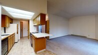 Located in Spokane Valley, WA, this single-floor unit offers a well-organized layout designed for comfortable everyday living. The spacious living room serves as the heart of the home, featuring plush carpeting, a tile-surround fireplace, and a sliding glass door that invites natural light and outdoor views. Vaulted ceilings add an open, airy quality to the living space, which flows naturally into the dining area, illuminated by a classic chandelier pendant light.

The kitchen is efficiently designed with warm wood-toned cabinetry, a white laminate countertop, a built-in electric range, and a full suite of appliances. A skylight overhead brightens the workspace throughout the day, while a peninsula with breakfast bar seating connects the kitchen to the living and dining areas. A dedicated pantry with multi-tiered shelving provides ample storage.

The bedrooms are generously sized, each finished with soft carpeting, baseboard heating, and windows that offer neighborhood views and natural daylight. The bathroom is clean and functional, equipped with a full tub-and-shower combination and tile flooring.

Throughout the unit, neutral tones, wood accents, and consistent flooring choices create a cohesive and practical living environment suited for a variety of lifestyles.