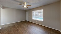 This 510 square foot apartment in Hurst, Texas offers a well-designed living space on a single floor. The open-concept layout maximizes the use of space, featuring a combined living and dining area that flows seamlessly into the kitchen. The living room is highlighted by a large window overlooking the community pool, filling the space with natural light.

The apartment boasts modern finishes throughout, including sleek wood-look flooring and neutral-toned walls. Ceiling fans in the main living area and bedroom provide comfort and air circulation. The kitchen, though not fully visible in the images, appears to have a pass-through window or breakfast bar, enhancing the open feel of the space.

The bedroom, measuring 150 square feet, includes a spacious closet with sliding doors, offering ample storage. The bathroom, while compact, features a clean, white design with a shower/tub combination. A sliding glass door in one of the rooms (likely the bedroom or living area) provides access to a private patio or balcony, extending the living space outdoors.

Despite its modest size, this apartment efficiently utilizes every square foot, creating a comfortable and functional living environment. The property's location at 1233 Cavender Dr in Hurst offers the convenience of suburban living with the amenity of a community pool.