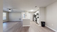 Located at 3004 Riverview Pl in Jonesboro, Georgia, this single-floor residence offers a clean, contemporary design with a neutral color palette and consistent flooring choices throughout. The open-concept kitchen and living area serves as the heart of the home, anchored by a central island with a built-in sink and white quartz countertop. The kitchen is outfitted with white shaker-style cabinetry, stainless steel appliances including a gas range, microwave, refrigerator, and dishwasher, and light wood-tone luxury vinyl plank flooring. The living area extends seamlessly from the kitchen, featuring wood-look LVP flooring, a ceiling fan, and a glass door with adjacent windows that invite natural light and provide outdoor access. Bedrooms are carpeted for comfort, each featuring ceiling fans and windows with blinds that bring in natural daylight. Two bathrooms serve the residence; one features a wide vanity with white cabinetry and a large mirror with lighted surround, while the second includes a full tub-shower combo, white cabinetry, and LVP flooring. The overall ambiance is bright, modern, and move-in ready, with cohesive finishes that lend a polished, well-maintained feel throughout every room.