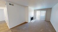 Located at 909 Tijeras Ave NW in Albuquerque, New Mexico, this single-floor, three-bedroom, two-bathroom residence offers a practical and comfortable layout. The carpeted living room serves as the heart of the home, featuring a fireplace with a tiled hearth and a sliding glass door with vertical blinds that fills the space with natural light and provides outdoor views. The kitchen is thoughtfully appointed with white cabinetry, light countertops, a stainless steel sink, a dishwasher, and a mosaic tile backsplash in warm earth tones, complemented by wood-look flooring. The three bedrooms are carpeted and bright, each featuring textured ceilings and ample wall space. The spacious primary bedroom includes a closet with built-in rods. Additional bedrooms feature windows with blinds that allow natural light. Both bathrooms are clean and functional; one includes a marble-look vanity countertop, a framed mirror, a mosaic tile accent, and tile flooring, while the second features a full tub-shower combination with white subway tile surround. The unit also includes a dedicated laundry area, a hallway, an entrance, and a closet, providing practical storage and everyday convenience throughout.