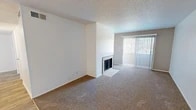 Located at 909 Tijeras Ave NW in Albuquerque, New Mexico, this single-floor, three-bedroom, two-bathroom residence offers a practical and comfortable layout. The carpeted living room serves as the heart of the home, featuring a fireplace with a tiled hearth and a sliding glass door with vertical blinds that fills the space with natural light and provides outdoor views. The kitchen is thoughtfully appointed with white cabinetry, light countertops, a stainless steel sink, a dishwasher, and a mosaic tile backsplash in warm earth tones, complemented by wood-look flooring. The three bedrooms are carpeted and bright, each featuring textured ceilings and ample wall space. The spacious primary bedroom includes a closet with built-in rods. Additional bedrooms feature windows with blinds that allow natural light. Both bathrooms are clean and functional; one includes a marble-look vanity countertop, a framed mirror, a mosaic tile accent, and tile flooring, while the second features a full tub-shower combination with white subway tile surround. The unit also includes a dedicated laundry area, a hallway, an entrance, and a closet, providing practical storage and everyday convenience throughout.