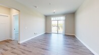 Located at 950 Jordan Creek Parkway in West Des Moines, Iowa, this well-appointed one-bedroom, one-bathroom unit offers a thoughtfully designed single-floor layout with a clean, modern aesthetic throughout. The open-concept kitchen and living area serves as the heart of the home, showcasing light wood-style flooring, soft neutral walls, and an abundance of natural light. The kitchen is a standout feature, equipped with white shaker cabinetry, quartz countertops, stainless steel appliances including a refrigerator, range, and microwave, and a central island with a deep undermount sink and stylish pendant lighting overhead. The living area extends to a private balcony through a sliding glass door, offering pleasant outdoor views. The bedroom is a comfortable retreat featuring plush carpeting, a ceiling fan, and three large windows that fill the room with natural light. The full bathroom includes a soaking tub and shower combination with tile surround, matte black fixtures, and direct access to a dedicated walk-in closet. A separate in-unit laundry room with wood-style flooring adds everyday convenience. Two closets and hallway spaces provide ample storage throughout this well-rounded, move-in ready home.