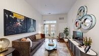Located at 2310 Woodland Crossing Dr in Herndon, Virginia, this thoughtfully designed single-floor residence offers a seamless blend of modern style and functional living. The living room is a standout, boasting impressively tall ceilings that amplify the sense of space, warm hardwood flooring, and a set of glass French doors that open to a private balcony, filling the room with natural light and views of the surrounding greenery. A dedicated dining area sits adjacent to the living space, providing an ideal setting for everyday meals or entertaining.

The kitchen is well-equipped with warm-toned cabinetry, dark granite countertops, a center island with seating, and a full suite of stainless steel appliances including a gas range and built-in microwave. Ample cabinetry extends to the ceiling, offering generous storage throughout.

The bedroom is a serene retreat, featuring elevated ceilings, a large window that invites natural light, plush carpeting, and direct access to a spacious walk-in closet with built-in shelving. The bathroom is clean and bright, finished with white cabinetry, tile flooring, and a tub-shower combination. Throughout the residence, a cohesive design palette of crisp whites and natural wood tones creates a warm and inviting atmosphere.
