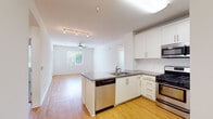 Located at 6701 Eton Ave in Canoga Park, California, this single-floor residence offers a bright, contemporary living environment with a thoughtfully designed open-concept layout. Warm bamboo hardwood flooring extends throughout the main living areas, creating a cohesive and inviting atmosphere, while ceiling fans provide comfortable air circulation in multiple rooms.

The kitchen serves as the centerpiece of the home, featuring white shaker-style cabinetry that reaches toward the ceiling for ample storage, a full suite of stainless steel appliances including a gas range, built-in microwave, dishwasher, and refrigerator, and a peninsula with a gray countertop and integrated sink. A white subway tile backsplash adds a clean, modern touch. The kitchen flows seamlessly into the open living area, which is bathed in natural light from a large window overlooking greenery outside.

The bedrooms offer plush carpeting, ceiling fans, and windows with blinds that bring in natural light while maintaining privacy. The bathroom is well-appointed with a tiled soaking tub and shower combination, wood-look flooring, and built-in wall shelving. Additional utility areas and accessible grab bars reflect thoughtful design considerations throughout the space.