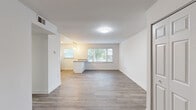 Located at 9704 Clark Place in Manassas, VA, this single-floor, three-bedroom, two-bathroom home offers a clean and modern living experience. The open-concept layout seamlessly connects the living room and kitchen, creating a bright, airy common area bathed in natural light from multiple windows. The kitchen is well-appointed with white shaker-style cabinetry, granite-look countertops, pendant lighting, and a full-size refrigerator, complemented by a peninsula that adds additional counter space and a natural divide between cooking and living areas. Consistent light-toned hardwood-style flooring runs throughout the home, lending warmth and visual continuity to every room. Each of the three bedrooms offers a comfortable, well-proportioned layout with dedicated closet space, neutral wall tones, and natural light. The primary bedroom provides a generous footprint with ample room for furnishings. The two bathrooms are finished with white vanities, framed mirrors, modern light fixtures, and tasteful wainscoting accents, conveying a clean and updated aesthetic. Two closets provide convenient storage throughout the home. The overall ambiance is bright, fresh, and move-in ready, making this Manassas home a practical and inviting space.