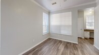 Located in San Marcos, TX, this two-story home offers 2 bedrooms and 3 bathrooms thoughtfully distributed across two floors. The main level features an open-concept kitchen and living area with hardwood-style flooring that flows seamlessly throughout. The kitchen is equipped with white cabinetry, dark granite-style countertops, a peninsula breakfast bar, and a skylight that fills the space with natural light. Crown molding adds a refined touch to the living area, which also benefits from large windows that invite abundant natural light. A dedicated utility room and an entrance area complete the first floor. Upstairs, both bedrooms feature soft carpeting, ceiling fans, and windows with outdoor views. The primary bedroom is a comfortable retreat with its own closet. The bathrooms are clean and functional, featuring granite-style countertops, a full tub-shower combination with white tile surround, and ample mirror space. Two staircases connect the floors, adding convenience to the layout. With a neutral color palette of soft grays and whites throughout, the home presents a bright, cohesive aesthetic well-suited for a variety of living arrangements.
