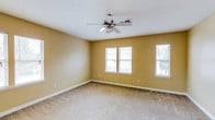This single-floor residence offers a practical and comfortable layout across one bedroom and one bathroom. The living area is generously proportioned, featuring warm beige walls, soft wall-to-wall carpeting, and a ceiling fan with integrated lighting that ensures year-round comfort. Multiple windows allow natural light to filter throughout the space, creating a bright and welcoming atmosphere.

A pass-through window connects the living area to the kitchen, enhancing the open feel between spaces. The kitchen is outfitted with warm wood-toned cabinetry, laminate countertops, and includes a full-size refrigerator, providing ample storage and functionality.

The bedroom is a well-sized retreat with carpeted flooring, multiple windows that invite natural light, and a ceiling fan overhead. Closet access is conveniently integrated into the room.

The bathroom is thoughtfully designed, featuring a vanity with a granite-style countertop, a full-size soaking tub with a shower, and a dedicated in-unit laundry area with a full-size washer and dryer — a practical amenity that adds significant convenience. Consistent warm beige tones and clean white trim carry throughout the space, lending a cohesive and neutral aesthetic that is easy to personalize.
