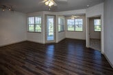 Located at 2415 Bridge Cir in Chattanooga, TN, this single-floor residence offers a well-designed layout with a variety of functional spaces. The living and dining areas feature rich hardwood-style flooring and are filled with natural light from large windows fitted with horizontal blinds. A sliding glass door leads to an outdoor area, extending the sense of openness. Ceiling fans throughout the unit provide additional comfort and airflow.

The kitchen is outfitted with dark espresso cabinetry extending to the ceiling for ample storage, light-toned countertops, and a full suite of stainless steel appliances including a refrigerator, range, and microwave. A pendant light and a double-basin sink add to its functionality.

The bedrooms are carpeted for warmth and comfort, each featuring a ceiling fan and a window with views of the surrounding greenery. The bathroom includes a full tub-shower combination with white tile surround and a curved curtain rod, complemented by a vanity with a large mirror and dark cabinetry. Hardwood-style flooring continues into the bathroom for a cohesive look.

A dedicated laundry area houses a full-sized washer and dryer with overhead shelving, adding practical convenience. Track lighting in the dining space and neutral-toned walls throughout create a clean, versatile interior ready for personalization.