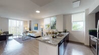 Located at 7951 NE Bayshore Ct in Miami's vibrant 33138 zip code, this modern single-floor residence offers a thoughtfully designed open-concept layout that seamlessly connects the kitchen, dining, and living areas. Light wood-style flooring runs throughout, creating a cohesive and airy aesthetic.

The kitchen is a standout feature, equipped with sleek dark cabinetry, granite countertops, stainless steel appliances, and a peninsula with a double sink that opens directly to the living space — ideal for entertaining. Multiple windows invite abundant natural light and lush greenery views into the kitchen and main living area.

The spacious living room is bright and welcoming, with floor-to-ceiling sliding doors that frame outdoor views and flood the space with Florida sunshine. The bedrooms are serene and well-proportioned, each with large windows offering tranquil garden views and ample closet storage.

The bathrooms reflect the same high-quality finishes found throughout the home. The primary bathroom features a double-sink vanity with granite countertops, dark cabinetry, and a backlit mirror, while a secondary bathroom offers a single granite vanity and a shower stall. Clean lines and neutral tones create a calm, sophisticated ambiance throughout this polished Miami residence.