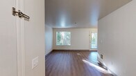 This one-bedroom, one-bathroom unit in Puyallup, WA offers a well-organized, single-level layout designed for comfortable everyday living. The open living and dining area is finished with warm wood-style flooring and neutral walls, allowing natural light to flow in through large windows that frame views of the surrounding greenery. A patio door provides direct access to a private outdoor area, where mature trees and landscaped grounds create a peaceful setting.

The kitchen is efficiently designed in a galley-style configuration, featuring light wood cabinetry, white countertops, a stainless steel sink, and white appliances including a range, microwave, and refrigerator. A breakfast bar separates the kitchen from the living area, adding a functional transition between spaces.

The bedroom is carpeted for comfort and includes a closet with sliding doors, a window with blinds for natural light and privacy, and a baseboard heater. The full bathroom offers light wood cabinetry, a single-basin vanity with white countertop, and wood-style flooring throughout.

Three closets provide generous storage throughout the unit. The combination of practical finishes, abundant natural light, and a lush outdoor setting makes this a functional and inviting space.