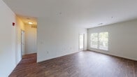 Located at 5211 Daybrook Circle in Rosedale, Maryland, this single-floor residence offers a clean, functional layout designed for comfortable everyday living. The open-concept living area is a standout feature, finished with rich hardwood-style flooring that extends throughout the main living spaces. Large windows along the exterior wall flood the room with natural light and offer views of the surrounding greenery, creating a bright and welcoming atmosphere. A door provides convenient access to the outdoors directly from the living area.

The kitchen is positioned adjacent to the living space and is accessible via a pass-through counter, maintaining an open and connected feel. It is equipped with warm-toned wood cabinetry, light-colored countertops, and a full suite of stainless steel appliances, including a gas range, over-the-range microwave, and refrigerator.

The bedrooms are carpeted for comfort and feature large windows that bring in ample natural light. At least one bedroom includes a walk-in closet, offering generous storage. The bathroom is finished with clean white tile surrounding a full soaking tub and shower combination, complemented by chrome fixtures for a classic, polished look. Throughout the space, neutral walls and consistent finishes create a cohesive and move-in ready environment.