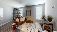 This single-floor residence offers a cohesive, modern design with quality finishes and a functional layout. The kitchen is a standout feature, showcasing white shaker-style cabinetry, granite countertops, a classic subway tile backsplash, and a full suite of stainless steel appliances including a refrigerator, electric range, microwave, and dishwasher. A built-in wine rack adds a refined touch, while rich hardwood-style flooring grounds the space with warmth and durability. The kitchen flows naturally into an inviting living area, where large windows allow ample natural light to fill the room, complemented by neutral gray walls that create a calm, versatile backdrop. The two bedrooms are carpeted for comfort, each equipped with a ceiling fan and windows with blinds. The primary bedroom connects directly to a well-organized bathroom featuring granite countertops, white cabinetry, and open shelving for convenient storage. A second bedroom is equally comfortable, offering a bright, serene atmosphere. Textured ceilings and consistent neutral tones are carried throughout the residence, tying the spaces together cohesively. The overall ambiance is clean, contemporary, and move-in ready, making this a practical yet stylish single-level home.