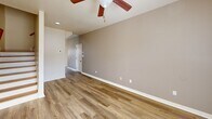 Located at 3101 Jenne Hill Dr in Columbia, MO, this two-story home offers four bedrooms, two full bathrooms, and an attached garage. The main level features a bright, open living area with warm-toned luxury vinyl plank flooring and a ceiling fan overhead. A staircase with wood-accented railings connects both floors seamlessly. The kitchen is a functional highlight, boasting light wood cabinetry, a tile backsplash, a central island, recessed lighting, and black appliances including a refrigerator, range, and dishwasher, complemented by a double sink beneath a window that brings in natural light. Both bathrooms are equipped with full tub-shower combinations and chrome fixtures. The four bedrooms are generously sized, with the spacious primary bedroom offering plush carpeting, a ceiling fan, and a window for natural light. Additional bedrooms also feature carpet, ceiling fans, and windows, with one room including a wall-mounted mini-split unit for individualized climate control. Throughout the home, neutral warm tones on the walls provide a clean, versatile backdrop. The upper level provides additional bedroom space, closets, and a hallway, making this home a well-organized and practical layout for everyday living.